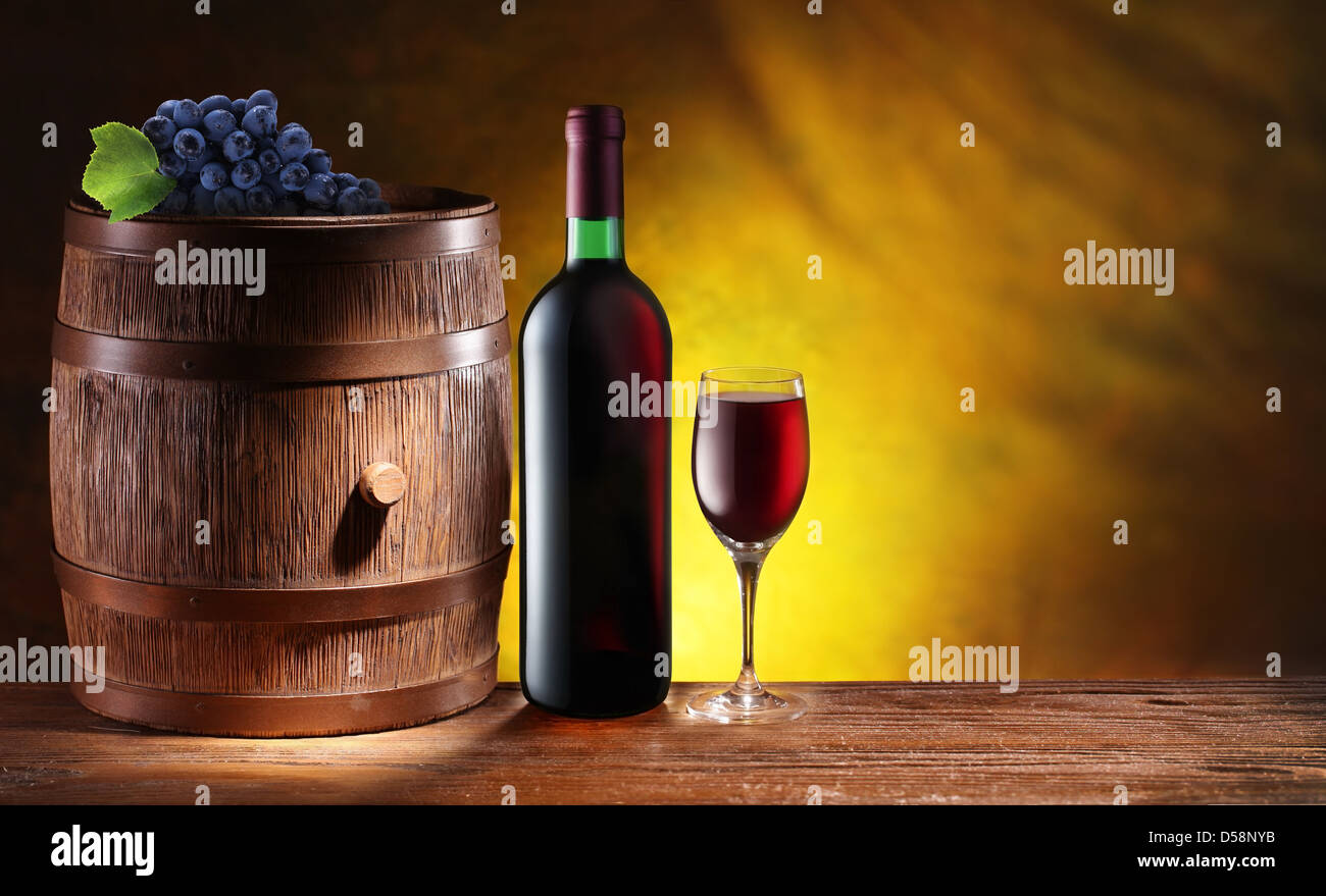 Bottiglia e un bicchiere di vino con un barile di legno scuro su sfondo giallo con un gradiente. Foto Stock