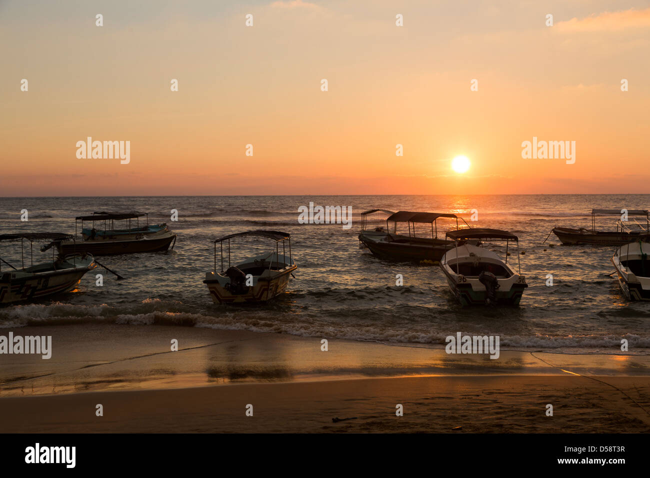 Molte barche al tramonto sulla spiaggia di Hikkaduwa nel sud dello Sri Lanka Foto Stock