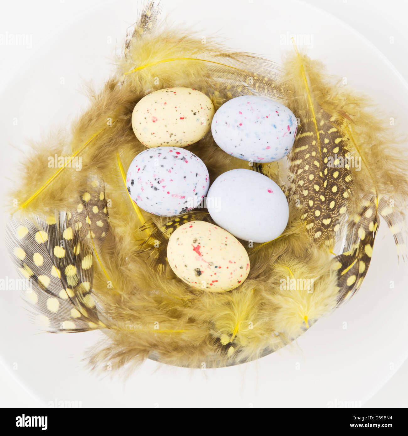 Pasqua messa in tavola per una cena di gala - una decorativa Yellow Nest con estere colorate uova su una piastra Foto Stock