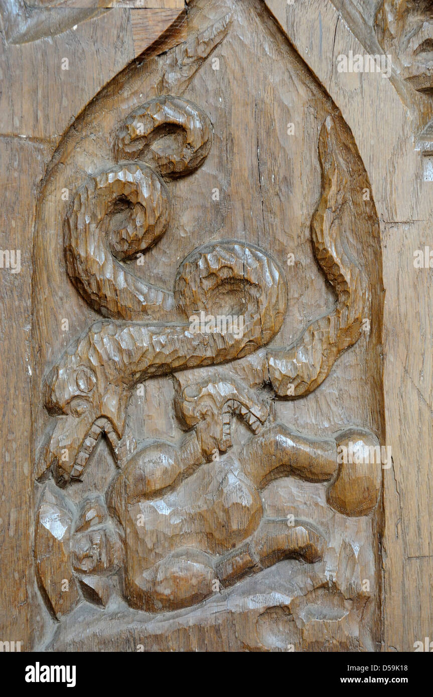 Stallo corale carving che mostra i serpenti consumando un uomo, Horning chiesa parrocchiale, Norfolk Broads Foto Stock