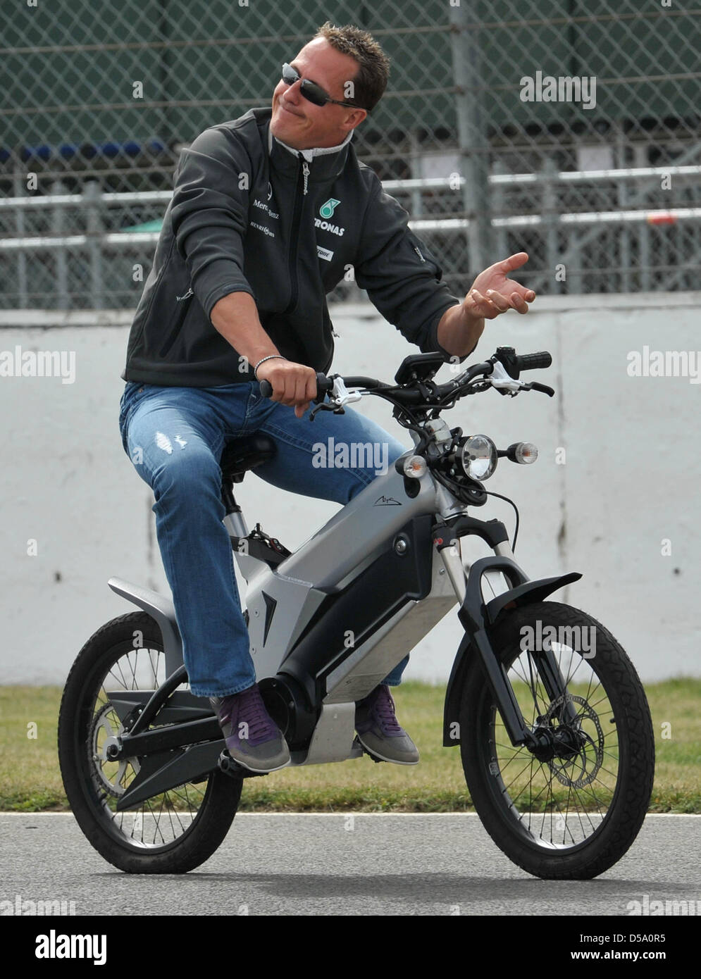 Der deutsche Formel-1-Rennfahrer Michael Schumacher von Mercedes GP am Donnerstag (08.07.2010) Mit einem elektrischem Fahrrad auf der Rennstrecke a Silverstone in Inghilterra. Am Wochenende avviato mit dem Gro§en Preis von Gro§britannien das zehnte Rennen der Formel-1-Saison 2010. Foto: Carmen Jaspersen dpa Foto Stock