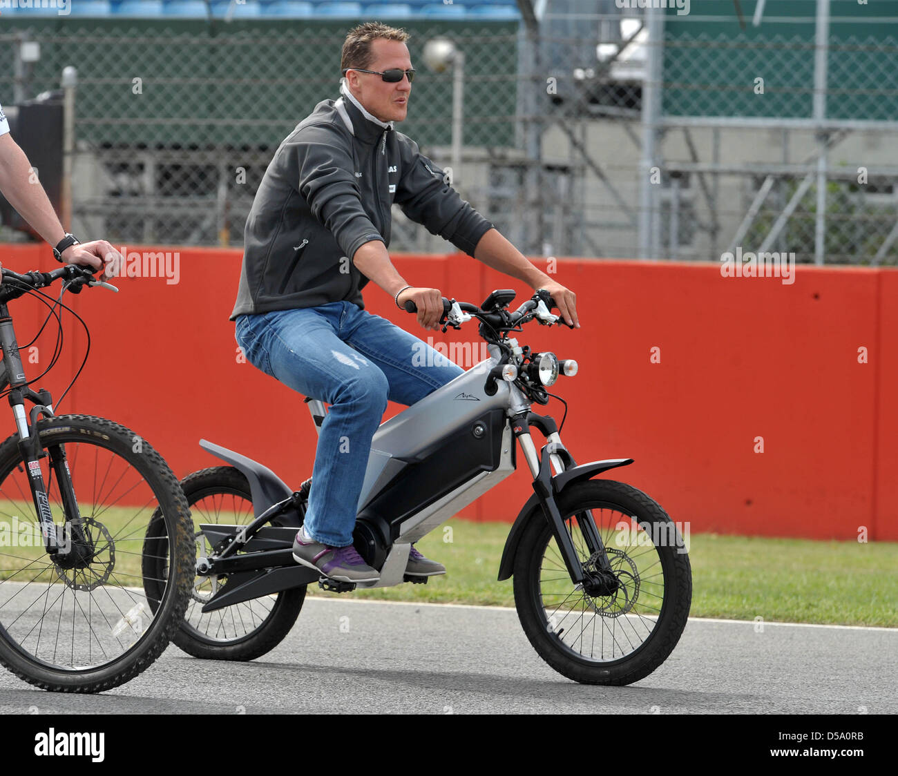 Der deutsche Formel-1-Rennfahrer Michael Schumacher von Mercedes GP am Donnerstag (08.07.2010) Mit einem elektrischem Fahrrad auf der Rennstrecke a Silverstone in Inghilterra. Am Wochenende avviato mit dem Gro§en Preis von Gro§britannien das zehnte Rennen der Formel-1-Saison 2010. Foto: Carmen Jaspersen dpa Foto Stock