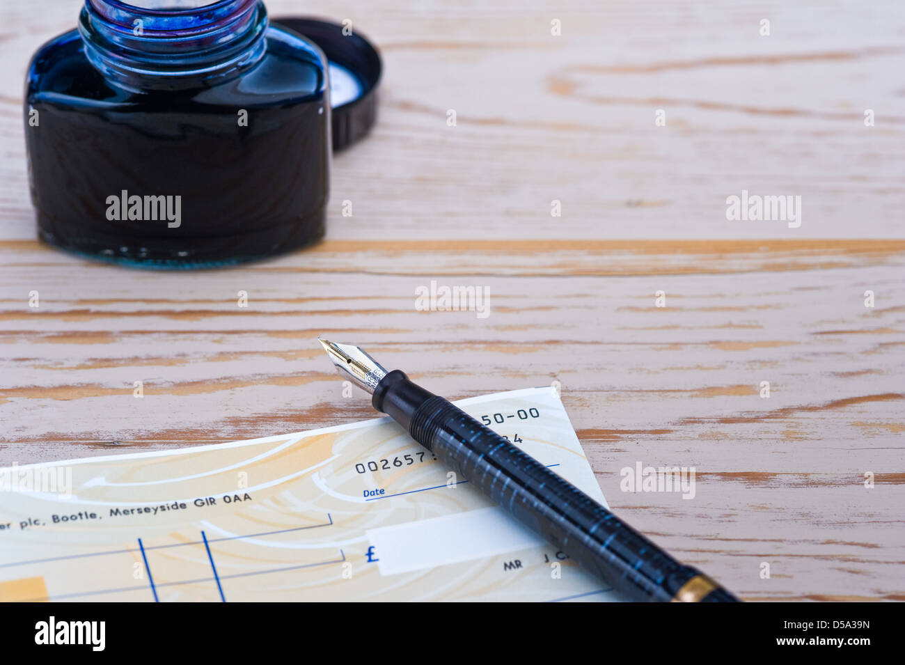 Verificare libro, penna e bottiglia di inchiostro. Foto Stock