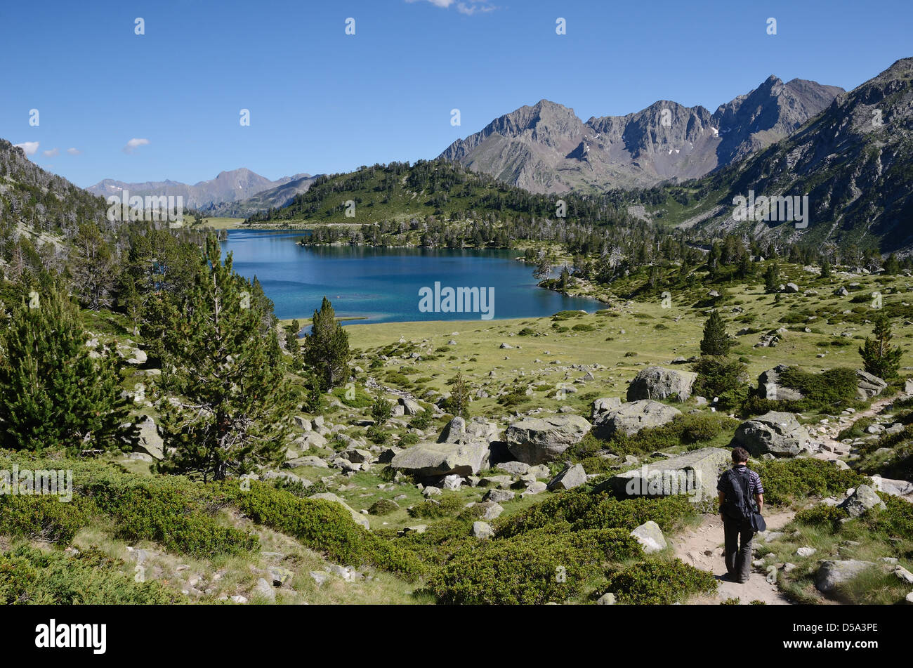 Escursionista che scende al lago di montagna Foto Stock