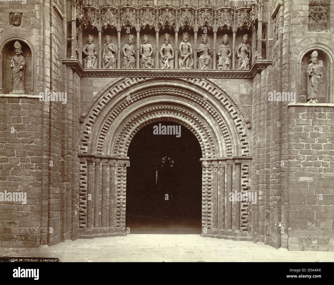 Il portico occidentale della cattedrale di Lincoln a Lincoln, in Inghilterra, presenta portali ad arco e nicchie adornate da sculture religiose, corone e simboli d'ufficio. Riflette il significato architettonico e religioso dell'edificio. Foto Stock
