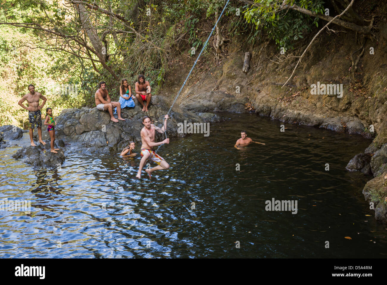 Oscillazione su una corda swing alla cascata di Montezuma, Playa Montezuma, Puntarenas Provincia, Costa Rica. Foto Stock