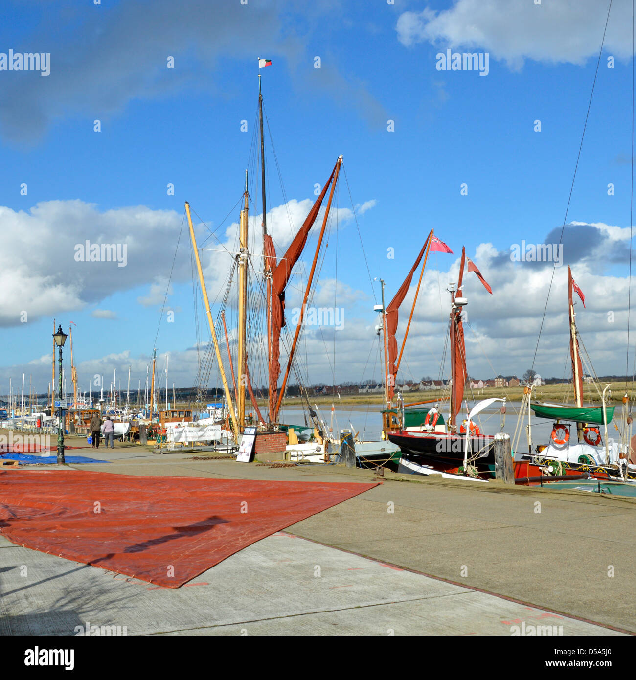 Passeggiata invernale accanto al fiume Blackwater a Hythe Quay vela da chiatte Tamigi in cielo blu sole e bianco cotone nuvole di lana Maldon Essex UK Foto Stock