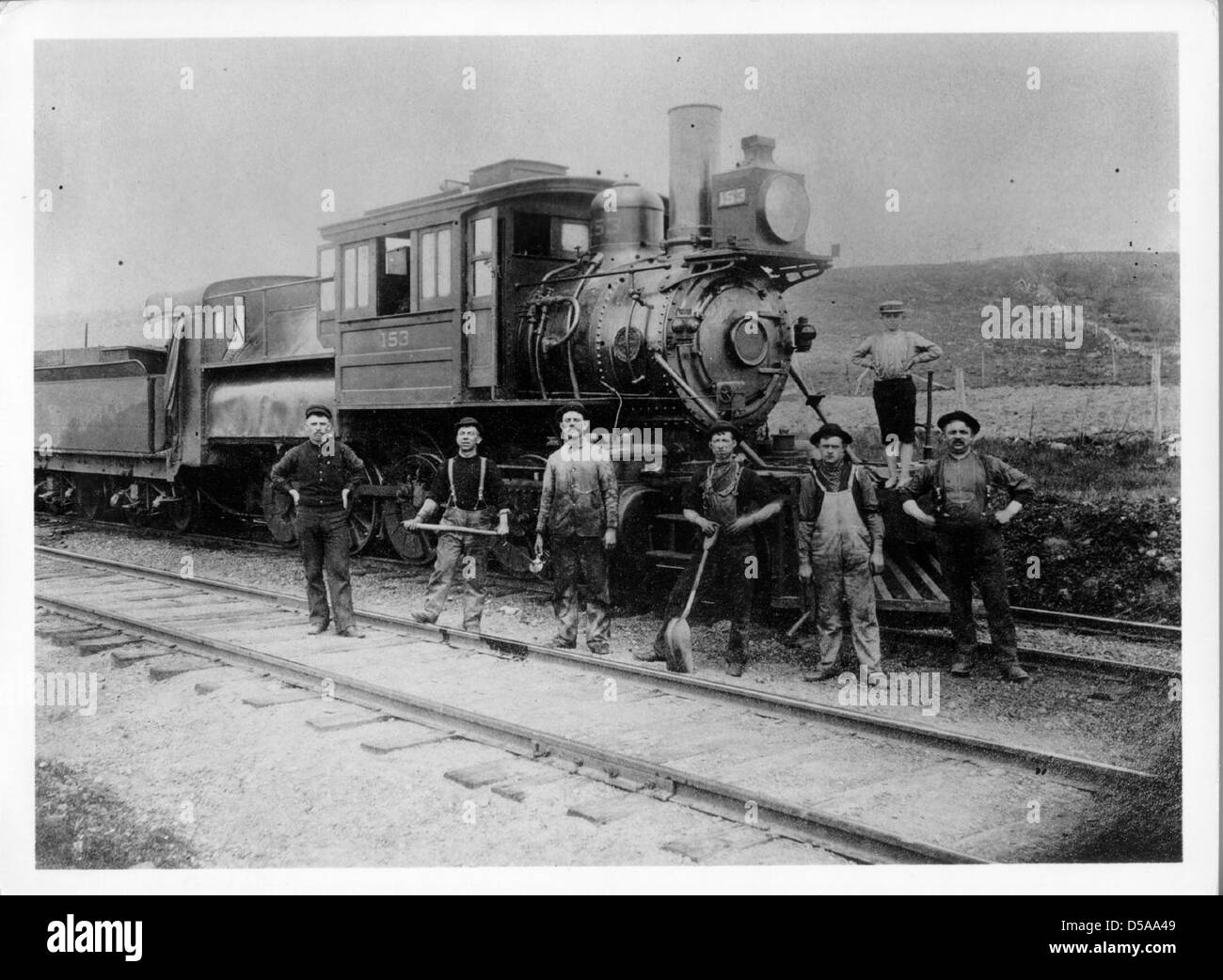 Fotografia di loco #153, una prima locomotiva, con lavoratori in piedi accanto ad essa. L'immagine cattura lo sviluppo dell'industria ferroviaria alla fine del XIX secolo. Foto Stock