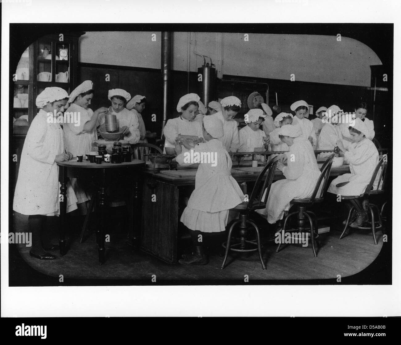 Una fotografia del 1915-18 circa che mostra due ragazze in un programma Junior Extension che imparano come fare le carote come parte dell'educazione all'economia domestica e della sensibilizzazione agricola. Foto Stock