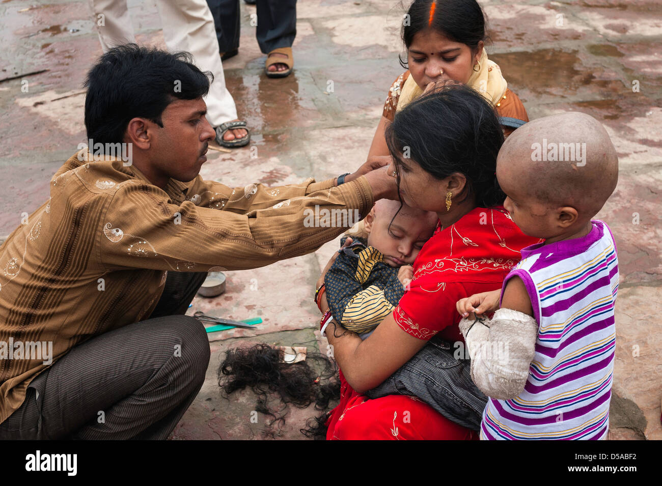 La rasatura una giovane testa del bambino come parte di iniziazione indù e la detersione di cerimonia in Varanasi (India). Foto Stock