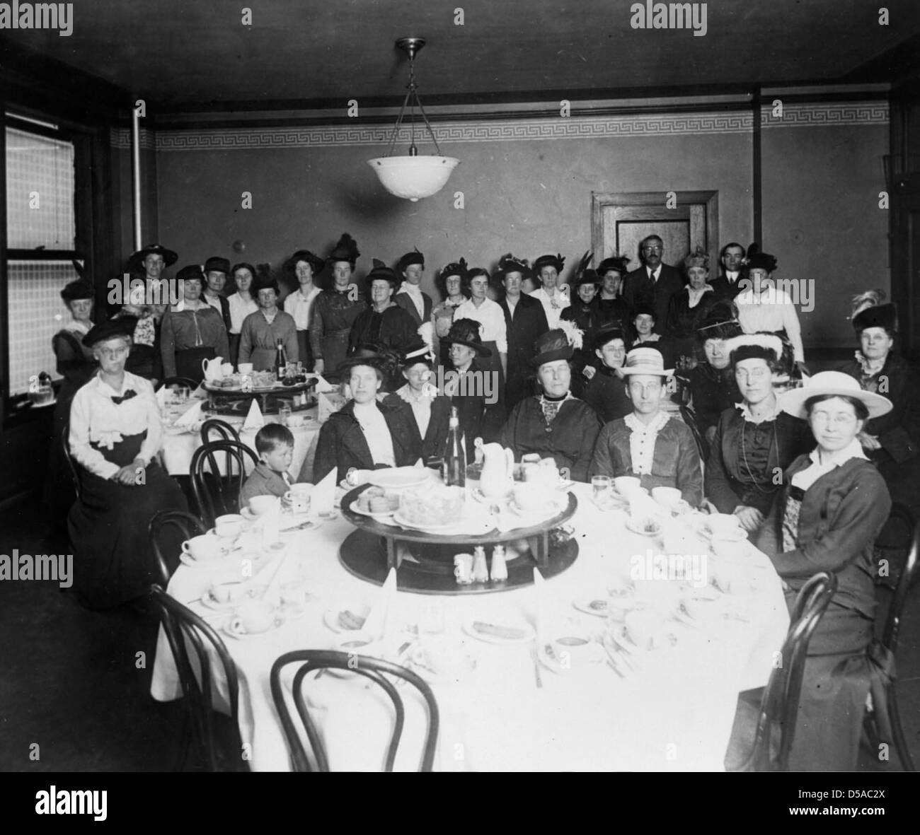 Questa fotografia non datata della Cornell University Library cattura un gruppo di individui impegnati in un'attività al chiuso, probabilmente legata all'economia domestica. L'immagine rimane non identificata, ma offre informazioni sulle pratiche di educazione domestica dei primi anni del XX secolo. Foto Stock