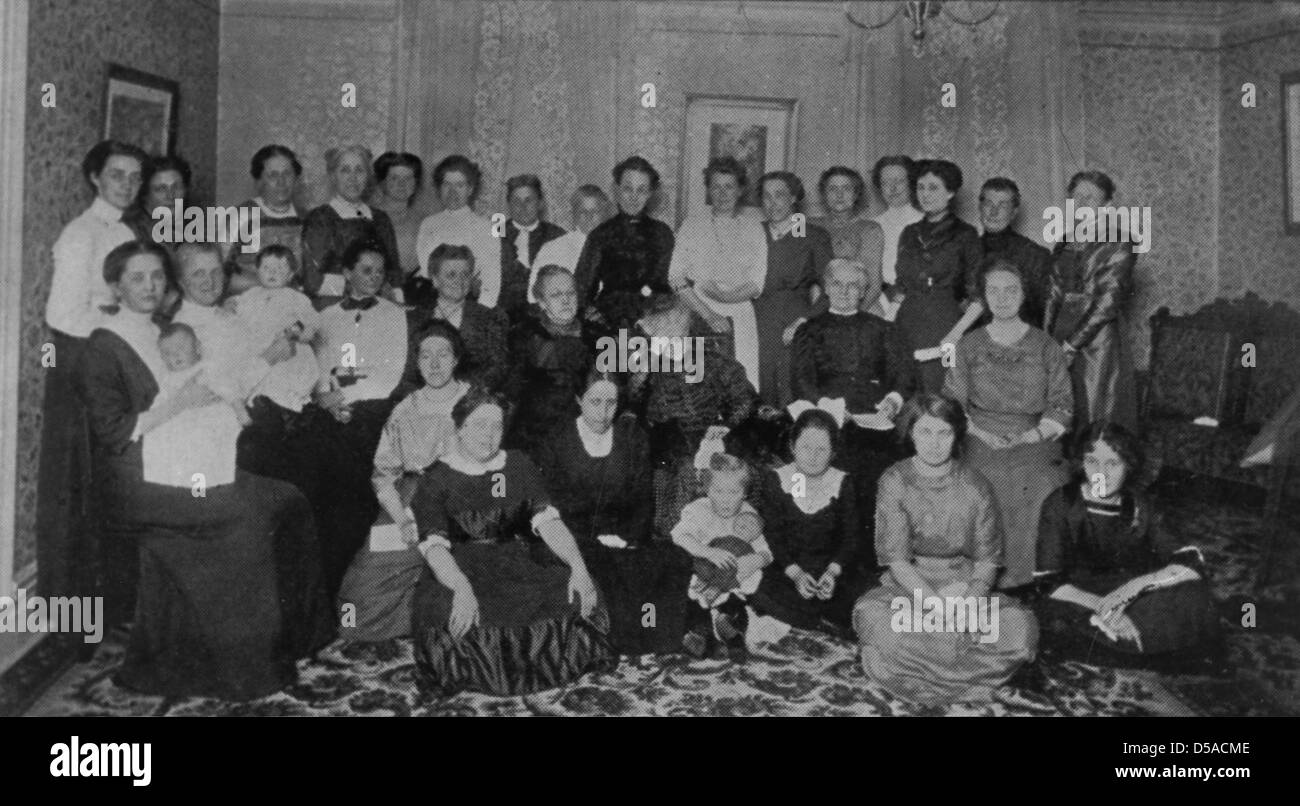 Una fotografia non identificata e non datata che mostra un gruppo al chiuso, probabilmente correlata all'economia domestica. La foto cattura un ambiente domestico o educativo, offrendo uno sguardo alle pratiche sociali o educative storiche. Foto Stock