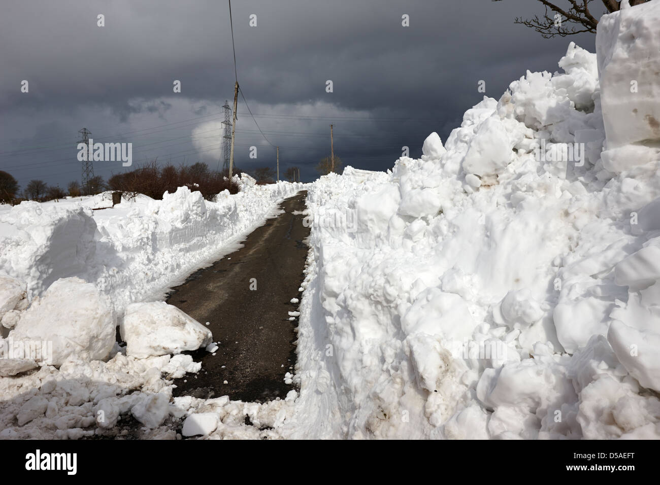 Vicolo del paese con pesanti derive della neve nella contea di Antrim Irlanda del Nord Regno Unito Foto Stock