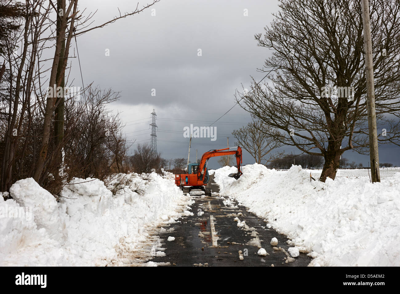Compensazione del trattore vicolo del paese con pesanti derive della neve nella contea di Antrim Irlanda del Nord Regno Unito Foto Stock