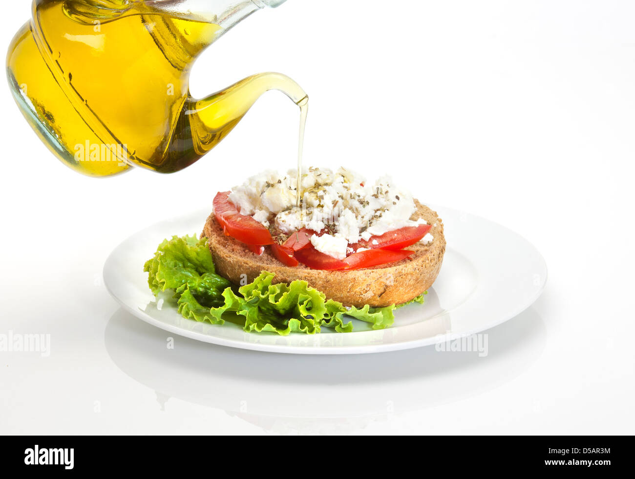 Tipico piatto cretese chiamato ntakos, una fetta di pane di orzo , cubetti di tmato, formaggio di capra, olio vergine di oliva e le erbe aromatiche Foto Stock