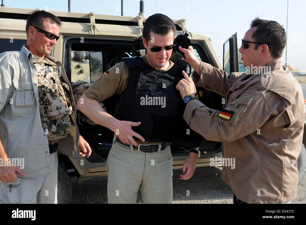 Il Ministro della difesa Karl Theodor zu Guttenberg è aiutato in un giubbotto antiproiettile all'accampamento militare della Bundeswehr in Masarè-I-Sharif, Afghanistan, 16 luglio 2010. Guttenberg visite Bundeswehr soldati delle truppe ISAF in Afghanistan. Foto: MAURIZIO GAMBARINI Foto Stock