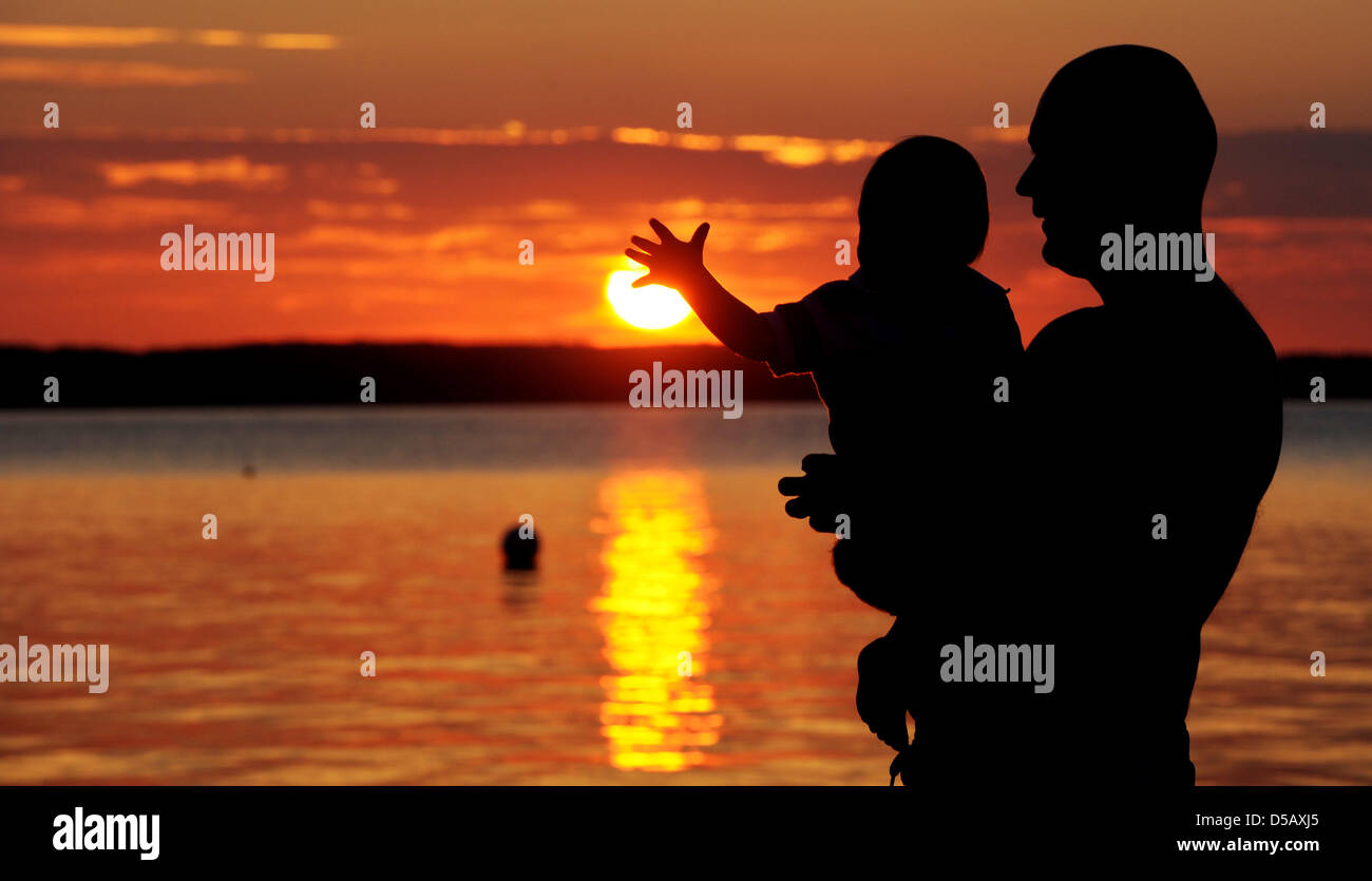 Un padre gioca con il suo bambino durante un fantastico tramonto vicino Noer, Germania, 19 luglio 2010. Foto: Julian Stratenschulte Foto Stock