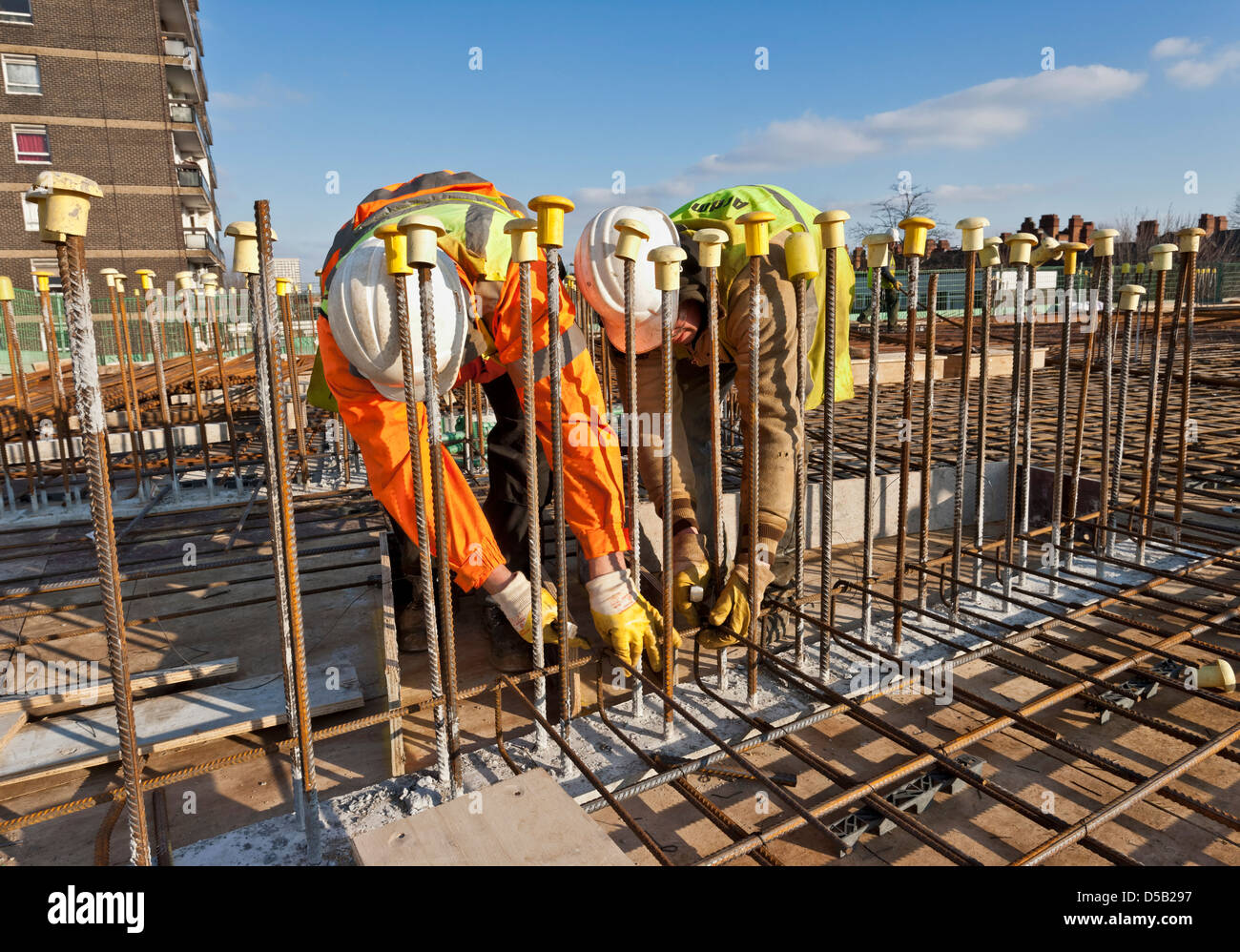Sito in costruzione i lavoratori la preparazione di acciaio per cemento armato versando Foto Stock