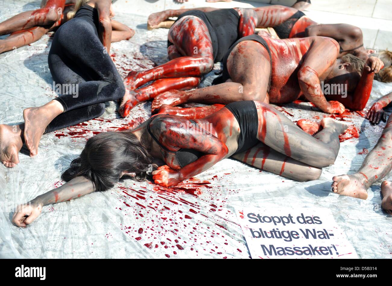 Colorate e coperte di sangue finto, Peta-attivisti si trovano di fronte all'Ambasciata Danese di Berlino, Germania, 5 agosto 2010. Dipinta come alalonga Balene Pilota, attivisti dei diritti degli animali organizzazione PETA Germania dimostrare contro il sloughter di alalonga galles pilota sulle Isole Faeroer. Foto: Rainer Jensen Foto Stock