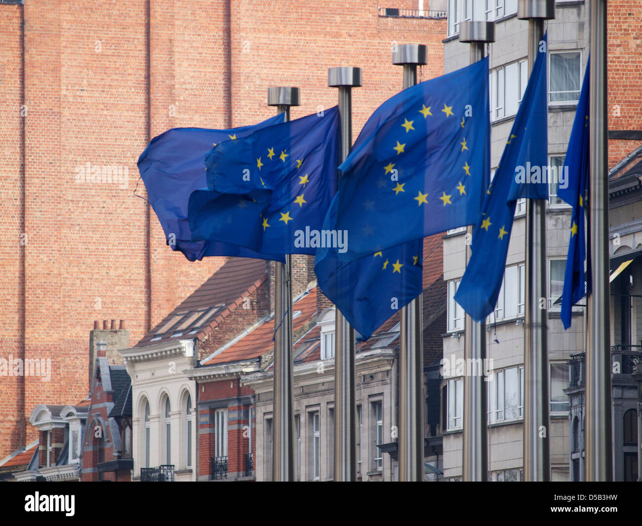 Unione Europea bandiere nel vento con vecchi edifici in background. Bruxelles, Belgio Foto Stock