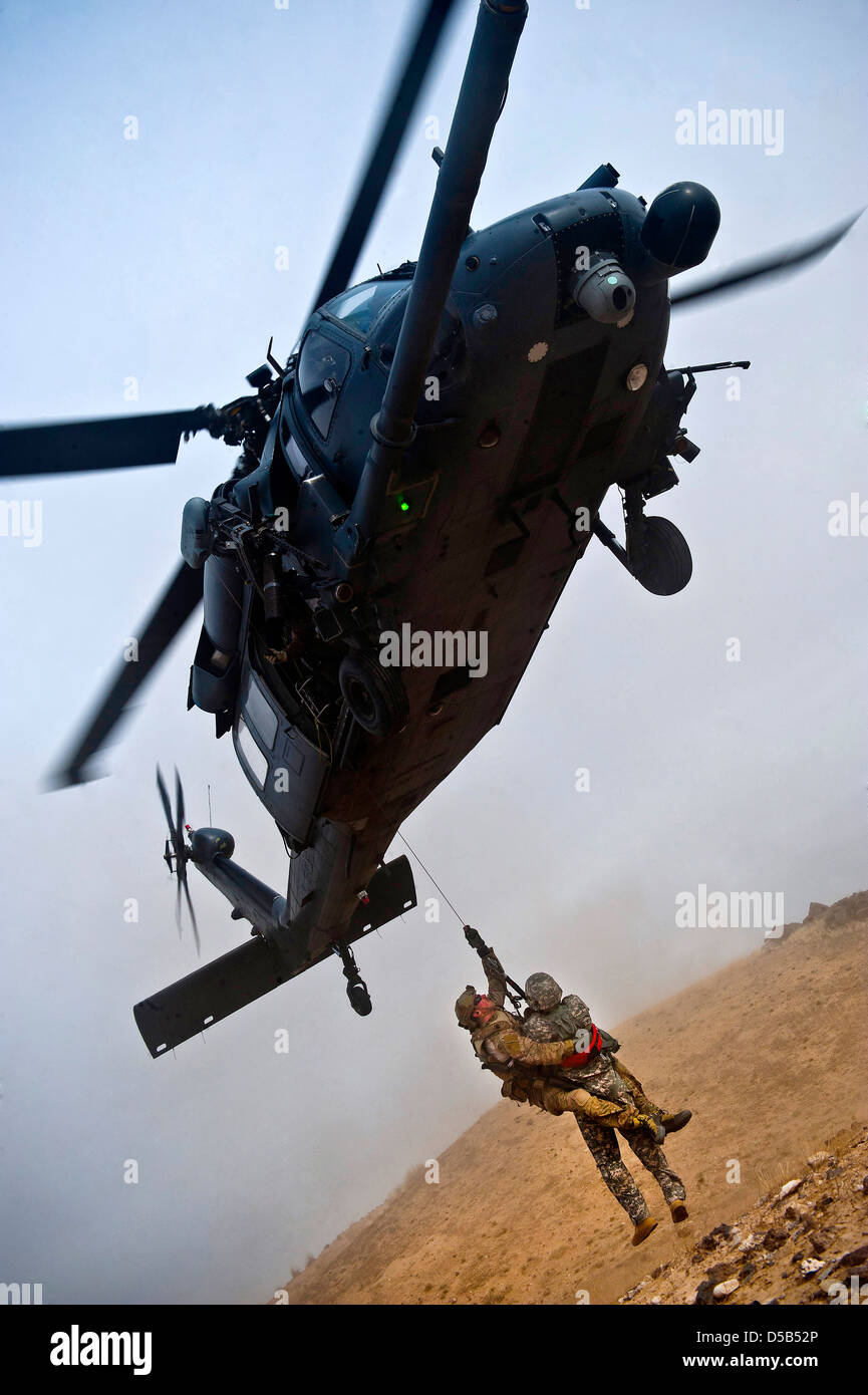 Un US Air Force HH-60 Pavehawk elicottero con la 66squadrone di salvataggio di paranchi la simulazione di una vittima di sicurezza durante un esercizio al 13 marzo 2013, presso il frutteto Combat Training Center, Idaho. Foto Stock