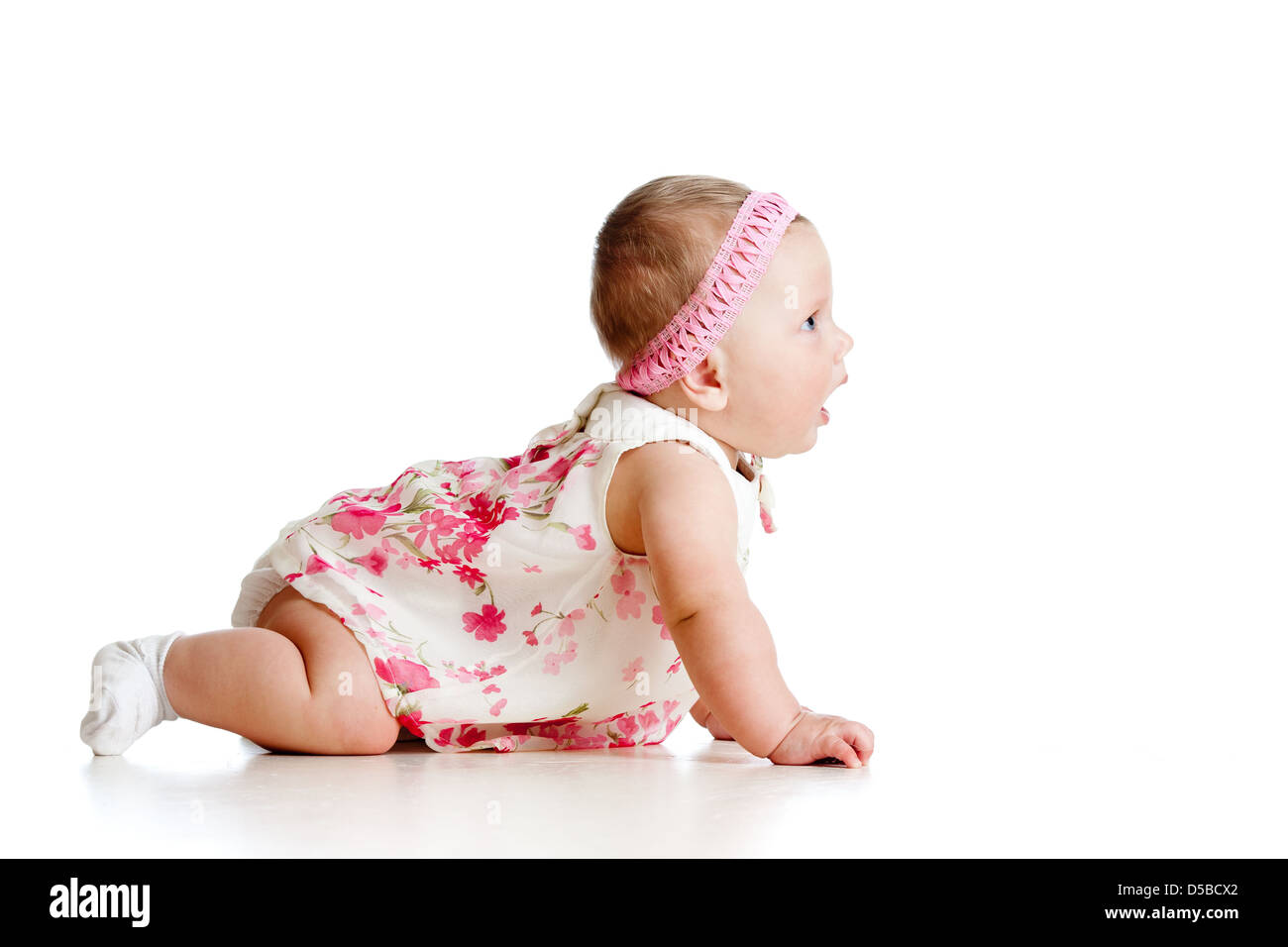 Vista laterale della graziosa bambina di strisciare sul pavimento Foto Stock