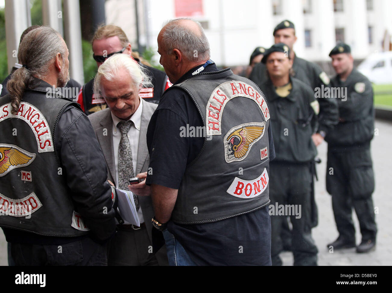 Sotto lo sguardo vigile di poliziotti, i membri del "Hell's Angels' moto club parlare di avvocato Ruediger Boehm (C) di fronte al tribunale regionale di Duisburg, Germania, 30 agosto 2010. Lo stesso giorno la Corte si pronuncia la sua sentenza di un 31-anno-vecchio membro del club che è accusato di fatalmente la ripresa di un membro del club rivale 'Bandidos' più di dieci mesi fa. Foto: OLIVER ESSERE Foto Stock