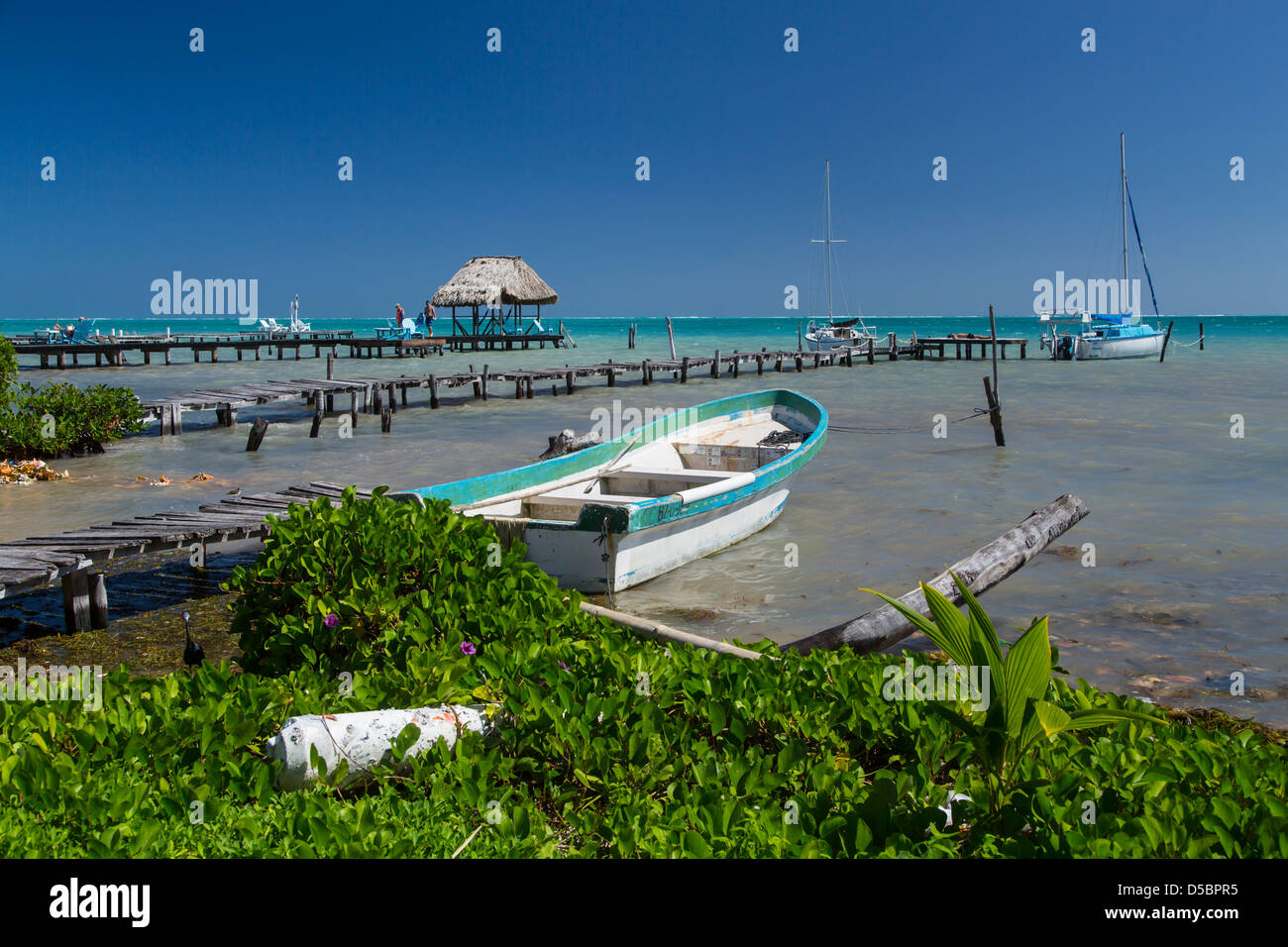 Un villaggio sulla spiaggia e il molo sull'isola tropicale di Cay Caulker, Belize, dei Caraibi. Foto Stock