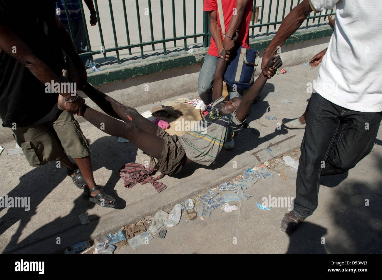 Una foto datata 15 gennaio 2010 mostra una vittima di martedì il terremoto di magnitudine 7.0 essendo precipitò dalla scena di Port au Prince, Haiti. I medici haitiani mendicare per aiutare nel mezzo di un disastro. WILLIAM B PLOWMAN/dpa (USA) Foto Stock