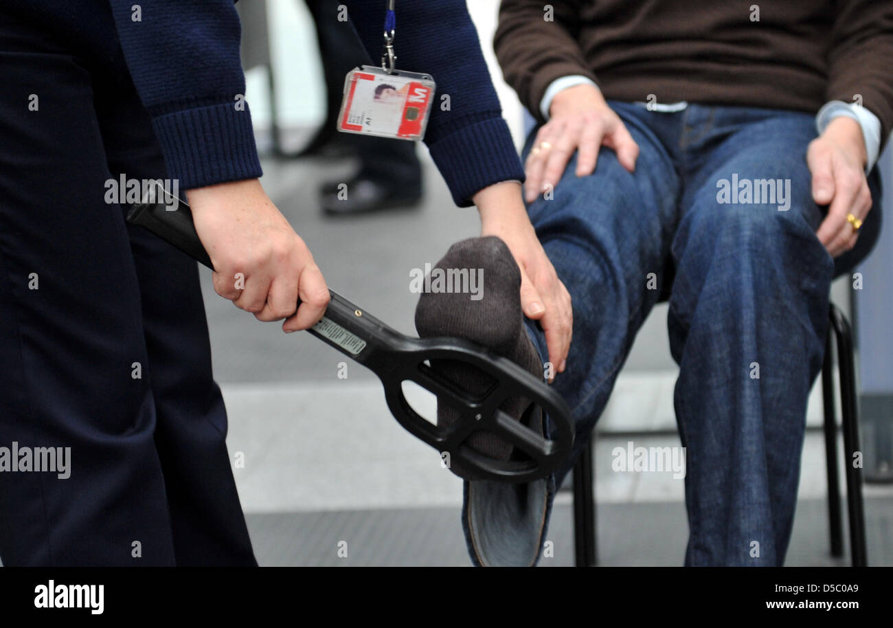 Controlli di sicurezza in aeroporto dipendenti controllare i passeggeri all'aeroporto di Monaco di Baviera, Germania, 22 gennaio 2010. Il 20 gennaio 2010, il computer portatile di un uomo all'aeroporto di Monaco di Baviera aveva impostato su off allarme bomba. Durante il controllo di sicurezza, il dispositivo di controllo aveva visualizzato possibile esplosivi. Successivamente l'uomo prese il computer con lui e scomparso traceless in mezzo alla folla. Dopo questa sicurezza glitc Foto Stock
