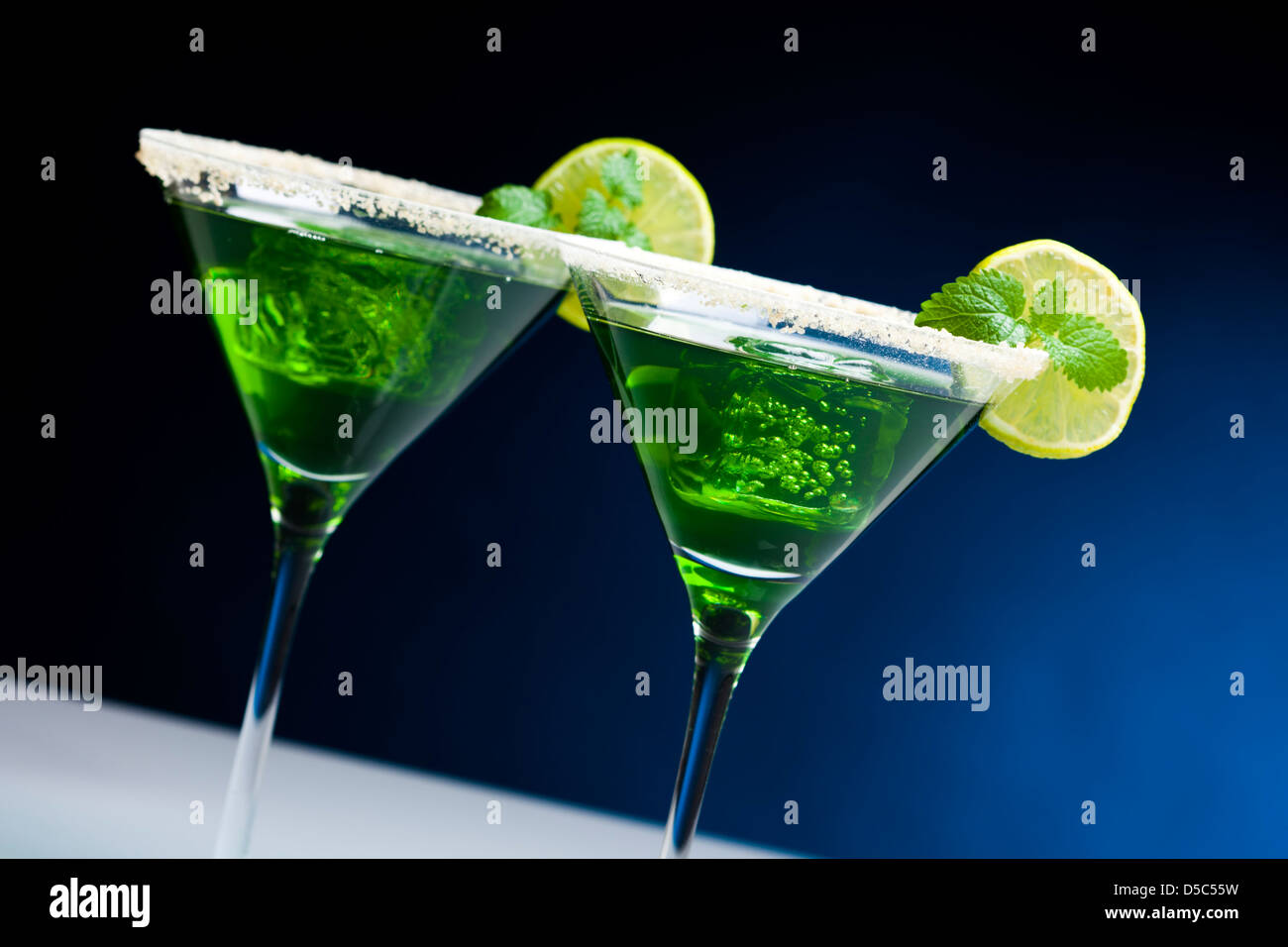 Green cocktail in bicchieri da martini con bordi zuccherato, fetta di lime, i cubetti di ghiaccio con foglie di menta Foto Stock