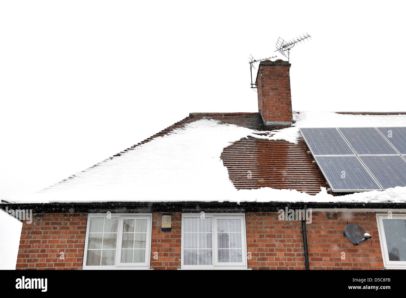 La fusione della neve sul tetto di un semi casa unifamiliare England Regno Unito Foto Stock