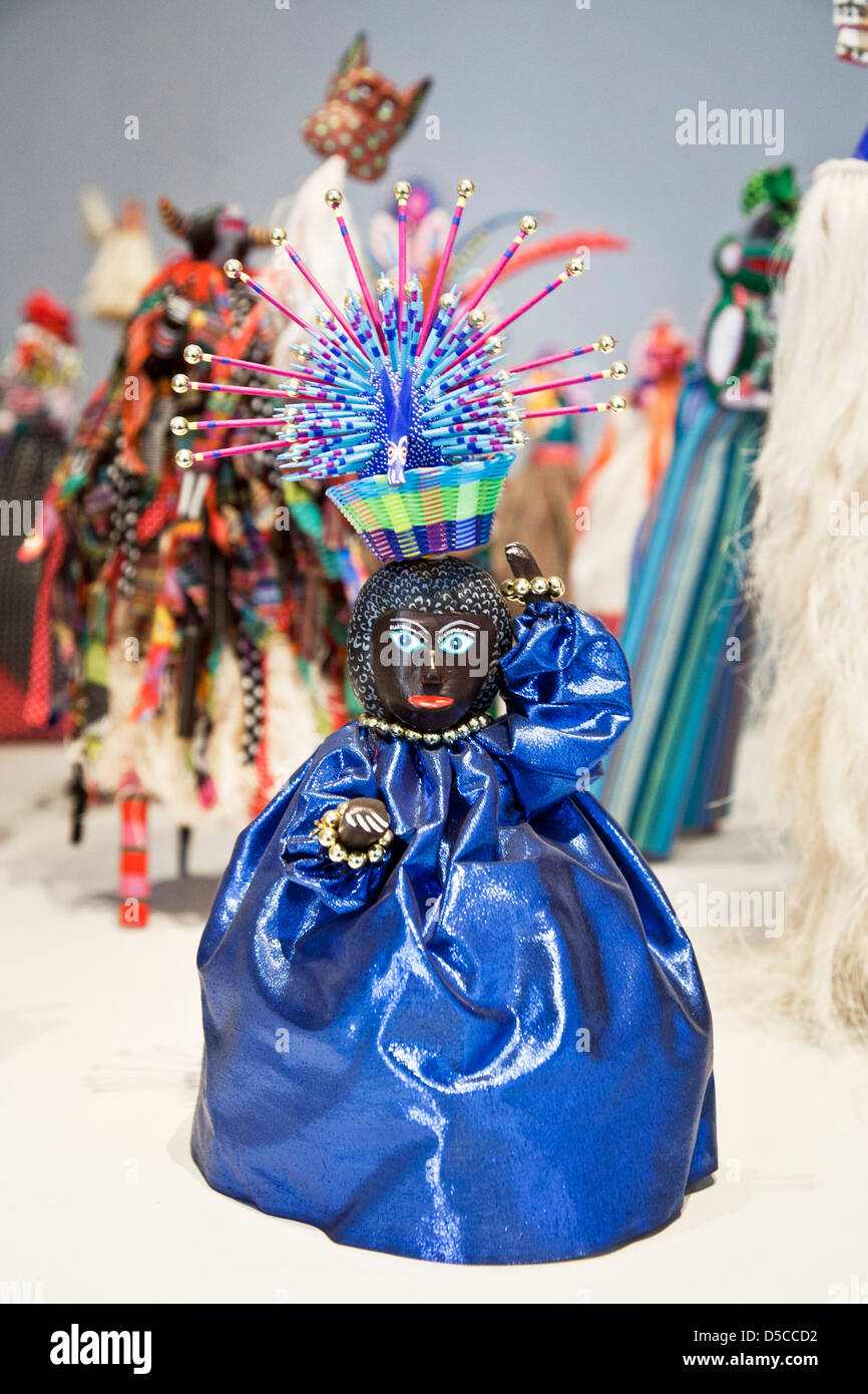 Ballerino nero in splendido costume blu con diadema visualizzato con gruppo miniatura stilt ballerini Museo de Textil Oaxaca Messico Foto Stock