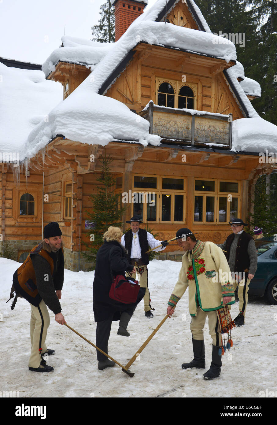 Turisti che si godono un team building sessione nella neve con i residenti locali vicino a Zakopane, Polonia Foto Stock