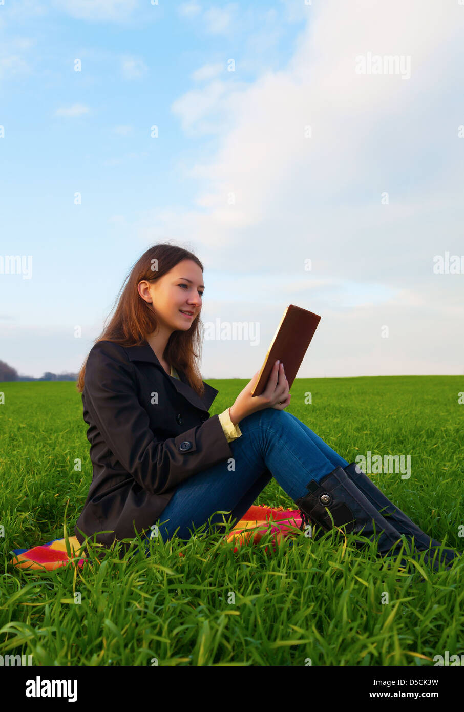 Teen girl leggendo la Bibbia seduti all'aperto al tramonto Foto Stock