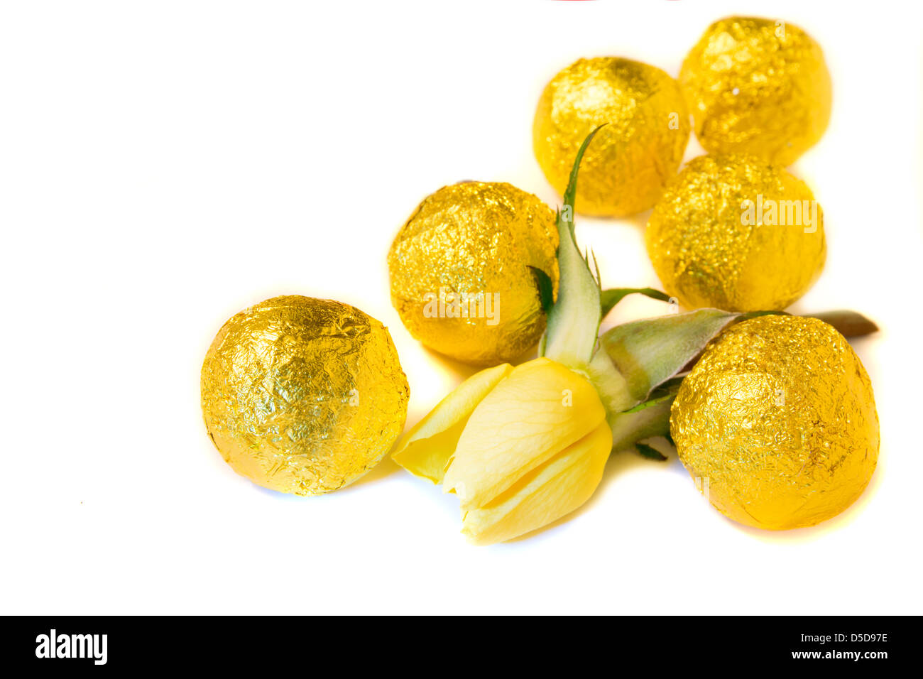 Caramelle e rosa gialla close up isolati su sfondo bianco. Messa a fuoco selettiva. Foto Stock