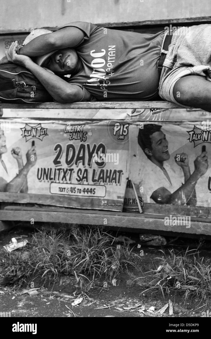 Uomo dorme sulla strada a Cagayan de Oro, Filippine Foto Stock