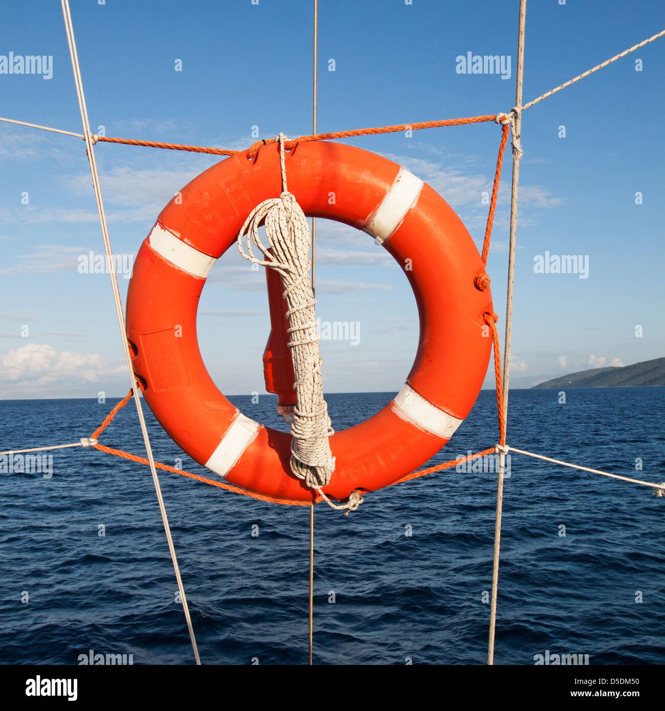 Un anello di soccorso attaccato ad accappatoi sul lato di una nave fuori in mare in una giornata di sole Foto Stock