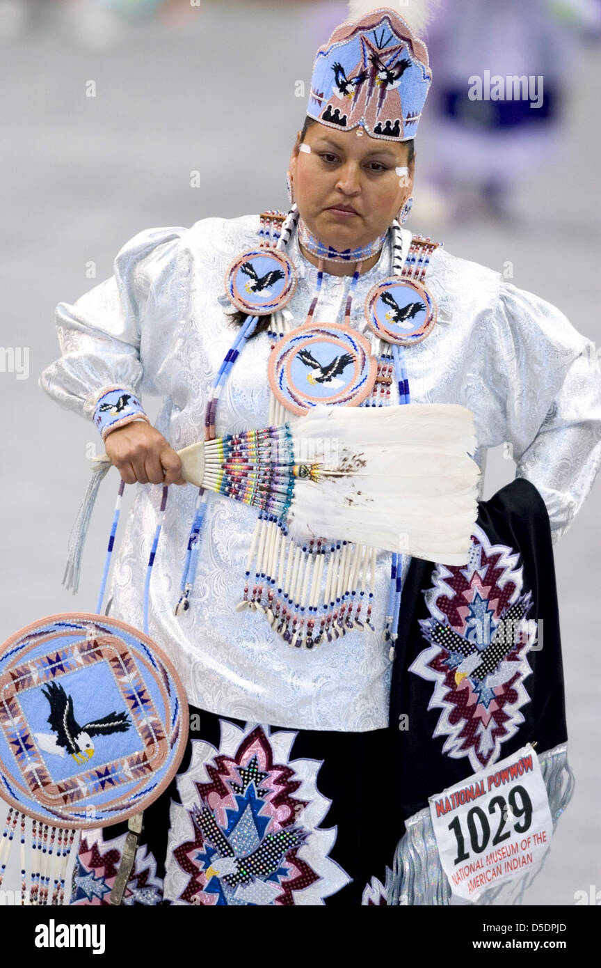 Una foto di una donna nativa americana in abito tradizionale al 2005 Powwow, che mostra un copricapo dettagliato e un costume con aquila adornato da piume e colori vivaci. L'immagine cattura il significato culturale degli incontri Powwow e dei regali dei nativi americani. Foto Stock