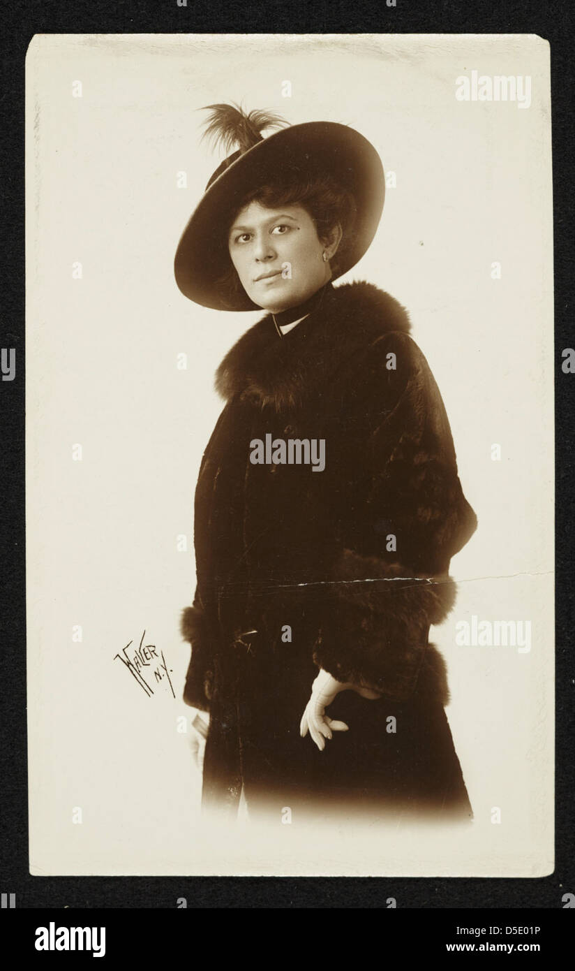 Questa fotografia in bianco e nero cattura una donna non identificata dei primi anni del XX secolo, vestita con un girocollo e un cappotto di pelliccia. La fotografia offre informazioni sui ruoli di moda e genere del tempo. Foto Stock