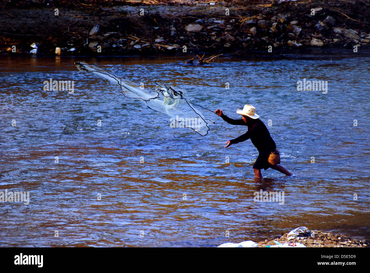 Pescatore solitario fusione il suo net sul fiume maechem in Chiang Mai Thailandia del Nord prese su 09/03/2009 Foto Stock