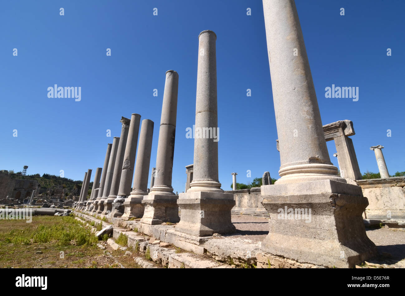 Linea di ben conservato antiche colonne greche contro un cielo blu chiaro Foto Stock