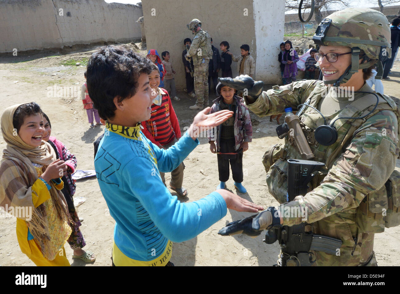 US Air Force Staff Sgt. Elizabeth Rosato, membro della 755th Expeditionary forze di sicurezza Squadron Team Mietitore smette di giocare con i bambini locali durante un villaggio patrol Marzo 11, 2013 vicino a Bagram Airfield, Afghanistan, . Il Mietitore team conduce le pattuglie nei pressi di Bagram Airfield contatore di ordigni esplosivi artigianali e indiretta di attacchi di fuoco nonché per impegnare locali' supporto nella protezione di base. Foto Stock