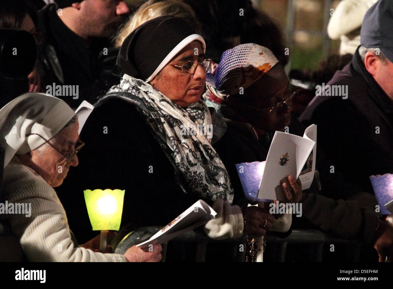 Il 29 marzo 2013, Colosseo Quadrato, Roma: le donne sono in grado di leggere il libretto di preghiere durante la Via Crucis presieduta dal Papa Francesco I intorno al Colosseo il Venerdì Santo. Le candele accese. Foto Stock