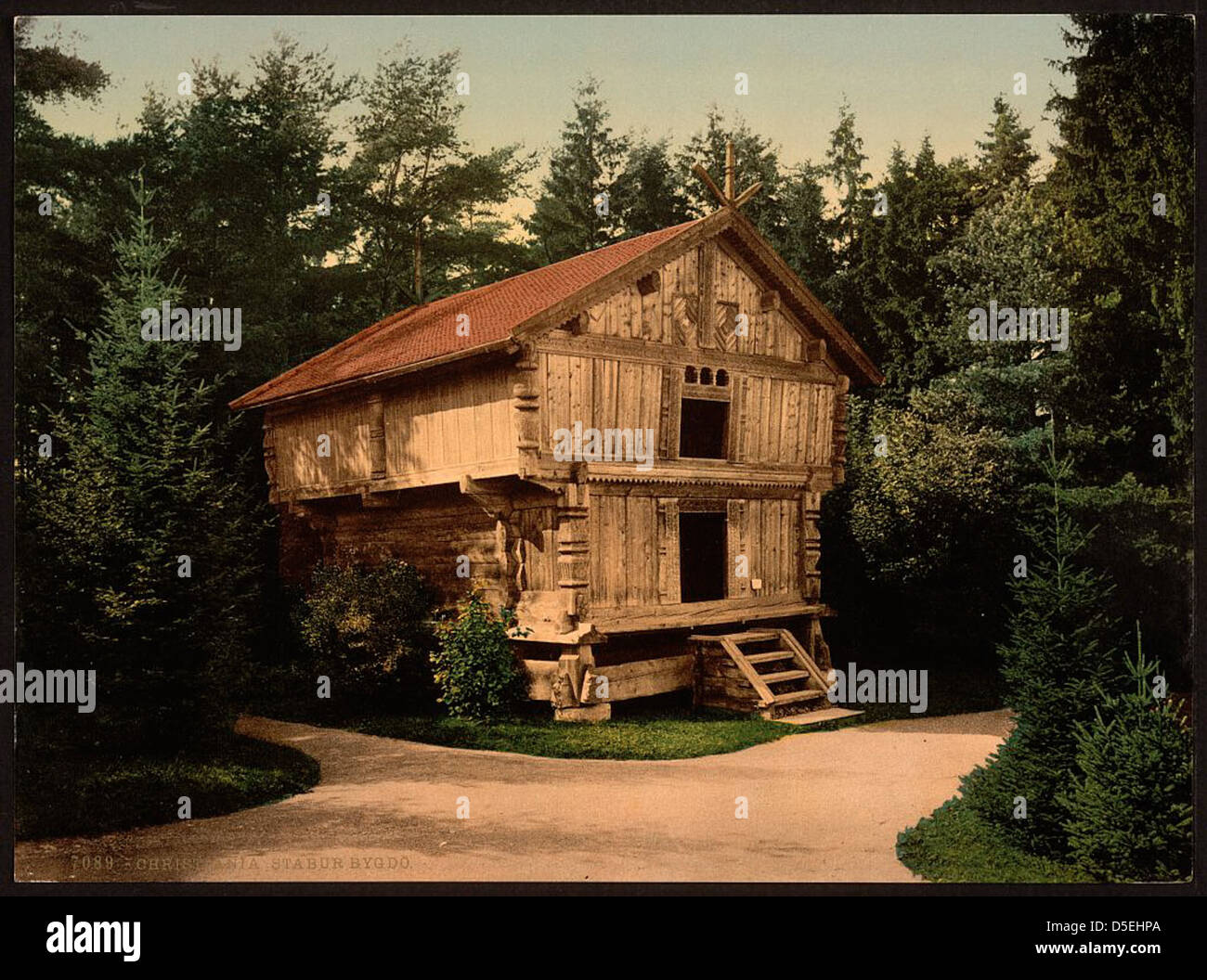 Una fotografia storica di Stabur Bygdo a Christiania, Norvegia, scattata dalla Detroit Publishing. L'immagine raffigura una tradizionale casa in legno circondata da alberi, catturando il fascino rustico dell'architettura rurale norvegese e la bellezza della campagna norvegese. Foto Stock