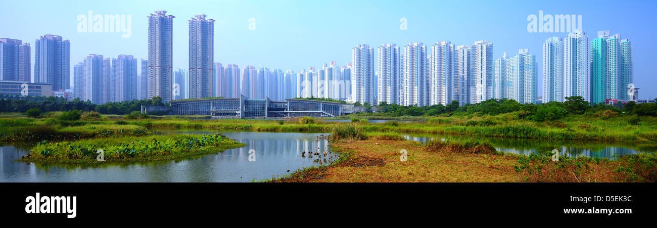 Alto edificio di appartamenti al di sopra del Parco delle Paludi di Hong Kong, Cina. Foto Stock