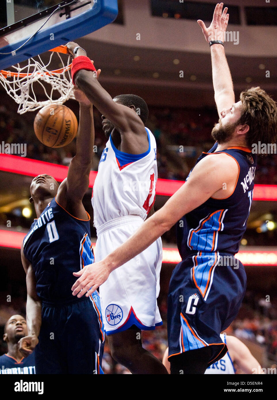 Philadelphia, Pennsylvania, USA. Il 30 marzo, 2013. 76ers' guard Jrue Holiday (11) schiacciate come Bobcats' centro Bismack Biyombo (0) e avanti Josh McRoberts (11) provare a difende nella seconda metà durante l Azione NBA tra Charlotte Bobcats e Philadelphia 76ers a Wells Fargo Center di Philadelphia, Pennsylvania. Il 76ers sconfitto i bobcats !00-92. Foto Stock