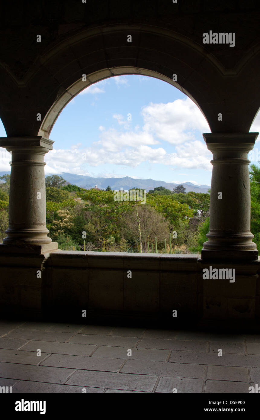 Guardando attraverso un arco nel Centro Cultural Santo Domingo oltre il Jardín Etnobotánico alle montagne in lontananza. Foto Stock