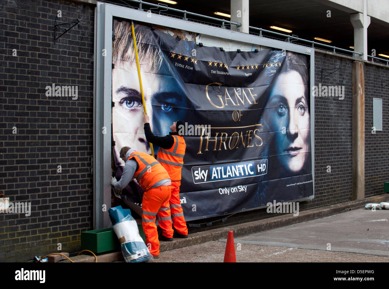 Gli uomini mettendo su affissioni poster, stazione di Coventry, Regno Unito Foto Stock