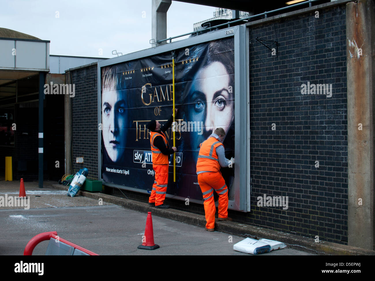 Gli uomini mettendo su affissioni poster, stazione di Coventry, Regno Unito Foto Stock